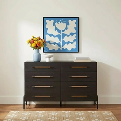 A dark dresser styled with blue artwork and yellow flowers